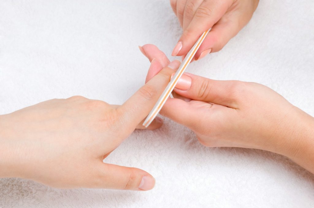 applying manicure with nail-file